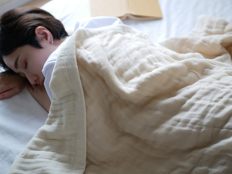 ココマニの綿100％5重織ガーゼケットがシングルサイズのベッドに掛けられ、快適な寝具として整えられている様子