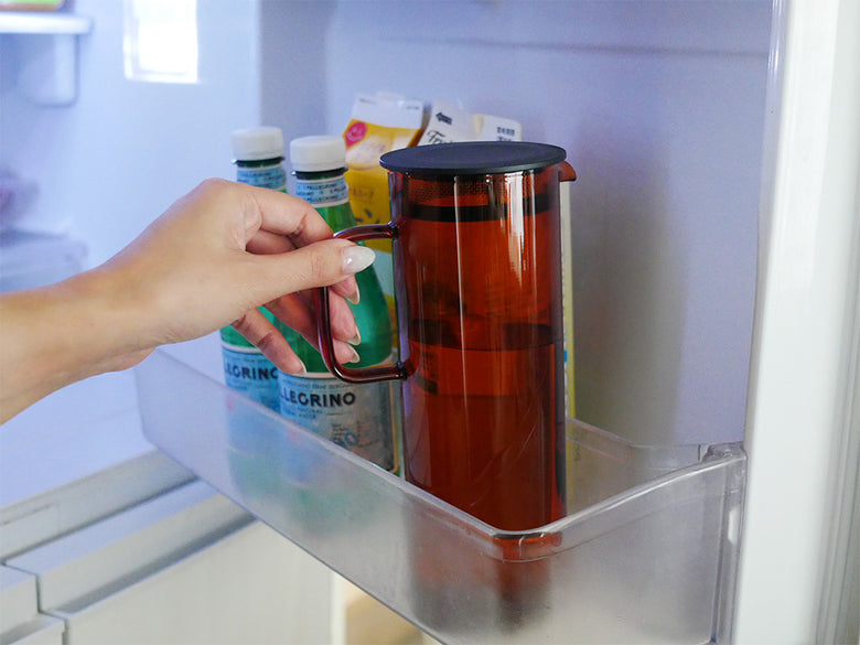 ハリオの耐熱ガラス製コールドブリューピッチャーとスタックマグカップのセット。グレーとアンバーの色合いで、キッチンでの飲料保存に最適です。