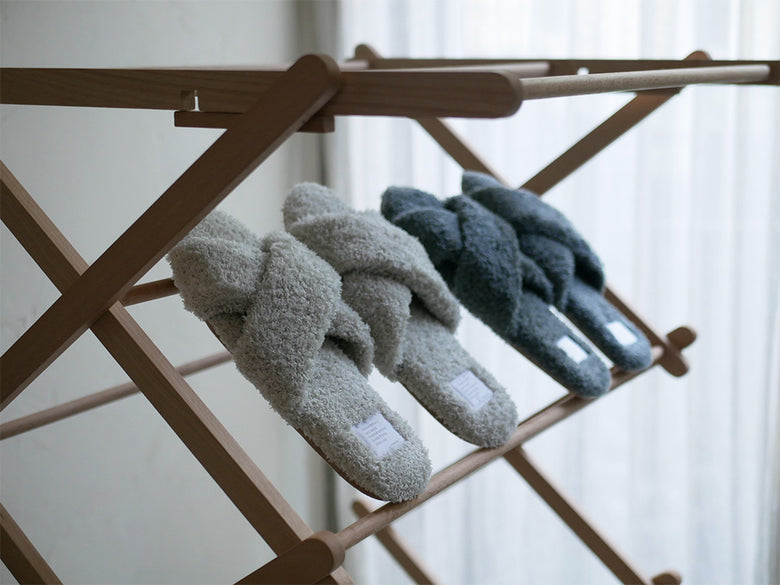サラサデザインの抗菌防臭パイルスリッパが、自然素材のバスケットや衣類ハンガーとともにディスプレイされた洗濯用品のセット。