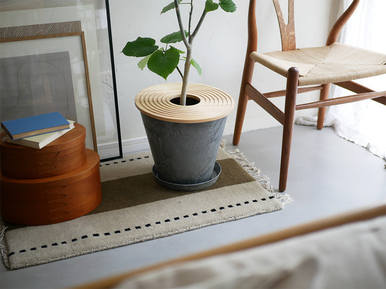 木材を使用した家具と木床、チェアやマットが配置された自然な室内空間