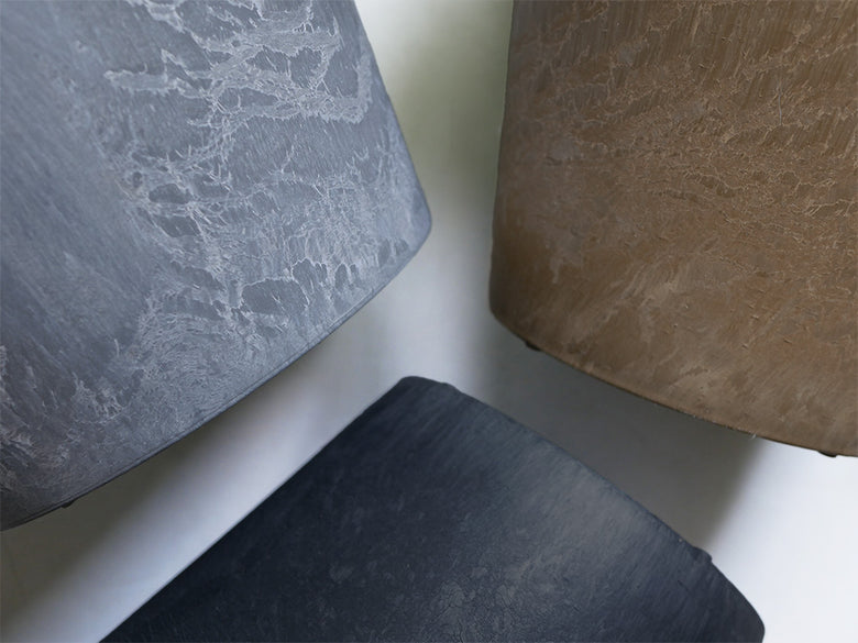 グレーの天然素材製プラントポットとソーサーのセット。屋内外で使えるスタイリッシュなデザイン。