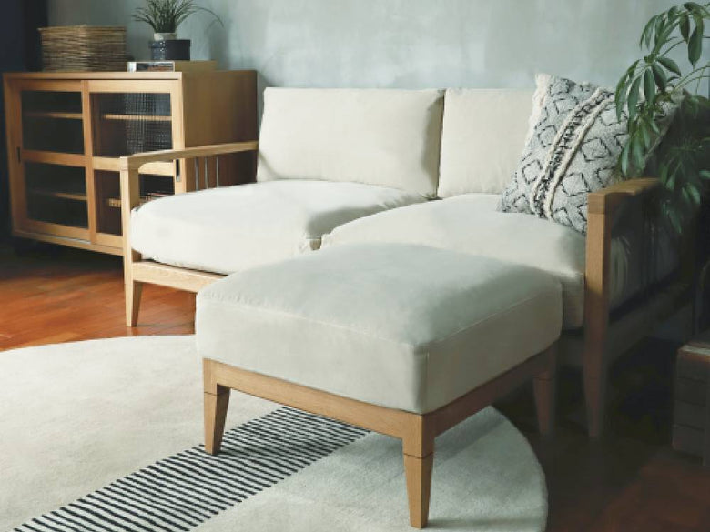 グレー色のソロソファーとクッションが配置されたモダンなリビングルームのインテリア