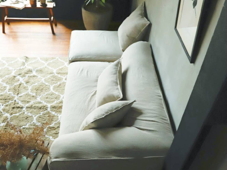 アデペシュのフレンチリネンソファとクッションが配置された居心地の良いリビングルームの写真