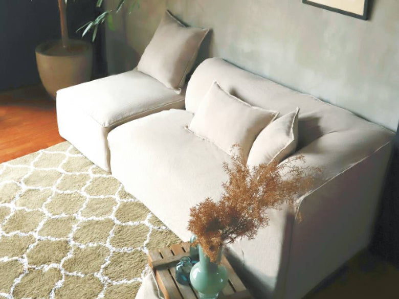 リビングルームに配置されたアデペシュのグレー色フレンチリネンソファ。クッションやスロー枕が飾られた快適な家具の様子