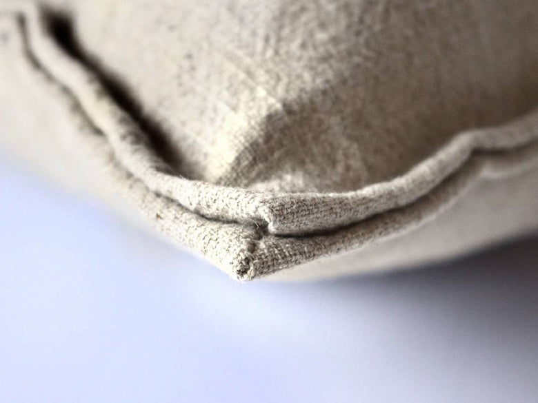 グレーのリネン製クッションが並べられたアデペシュのフレンチリネンソファ