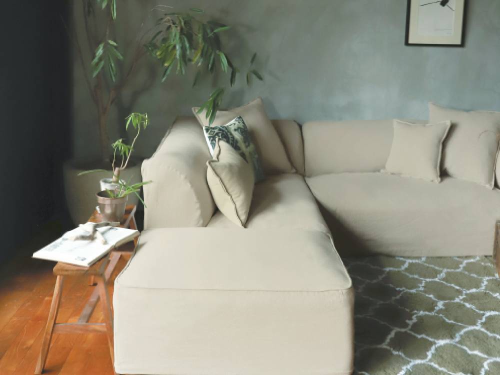 adepecheのフレンチリネンソファベッドと複数のクッションが配置された明るいリビングルーム