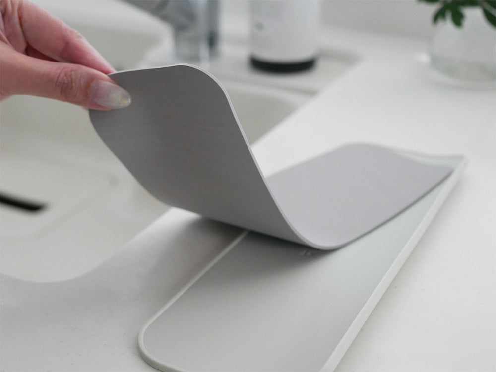 超速乾・超吸水2way水切りマット＆クロスがキッチンカウンターに置かれ、ライトグレーとブラックのカラーが見える画像