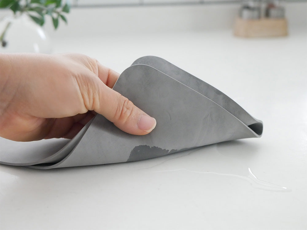 スッタの超速乾・超吸水2way水切りマット＆クロスがキッチン用品やアルミホイルと共に配置されている様子