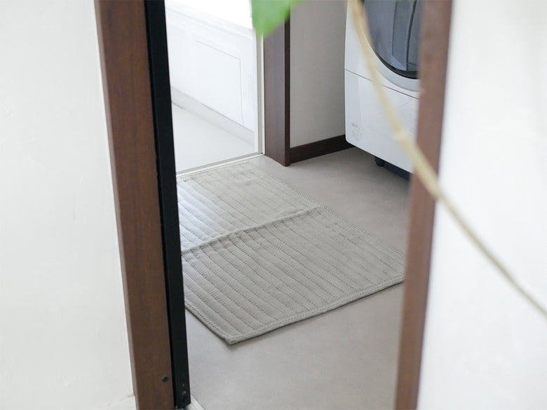 木製の床に敷かれた【OKATO】ゆったりサイズの足裏さらさらバスマット