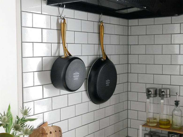 グリーンパンのセラミックコーティングフライパンとエッグパン、ステンレス製ガラス蓋がキッチンの調理スペースに整然と並べられた様子