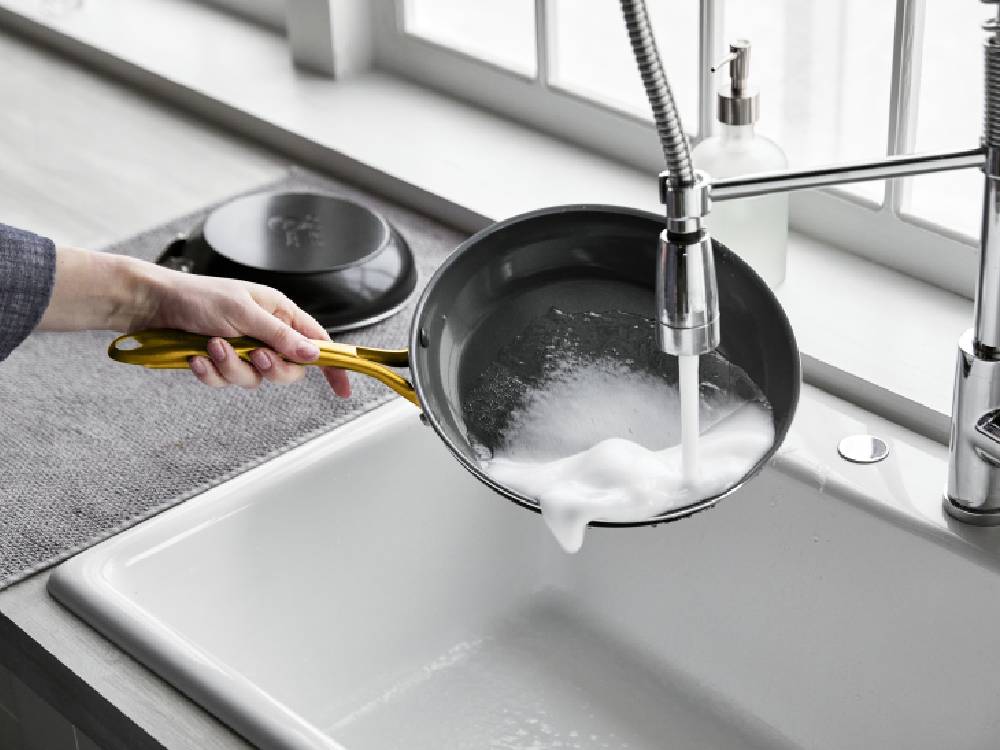 グリーンパンのストゥディオシリーズキャセロール、ソースパン、ミルクパンがキッチンの調理台に並べられている