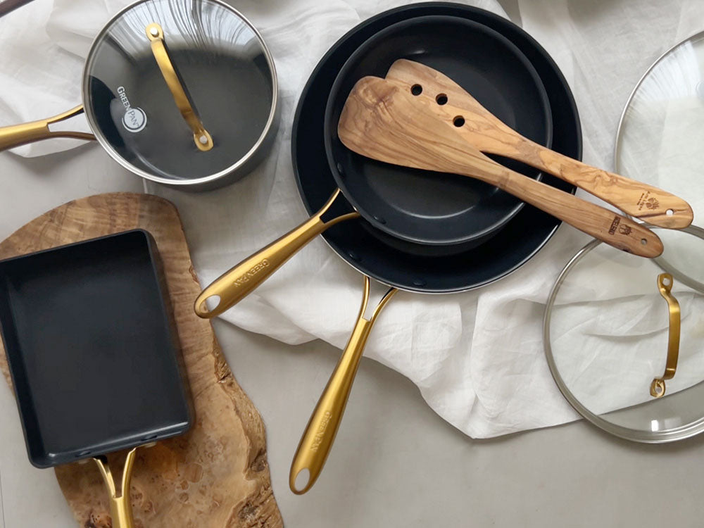 グリーンパン ストゥディオシリーズのセラミックコーティングされたキャセロール、ソースパン、ミルクパンがステンレス鋼のハンドル付きでキッチンに並べられている写真