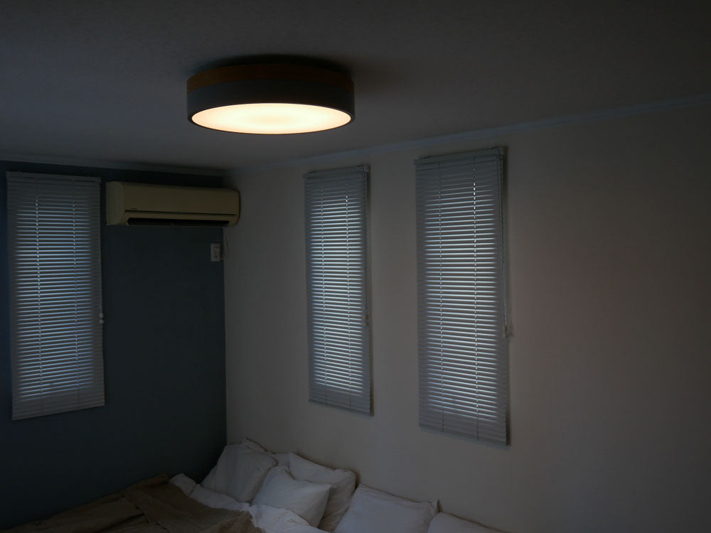 北欧カラーの天然木を使用したBRIDのLEDシーリングライトOlikaが、スタイリッシュな室内の天井に設置されている様子