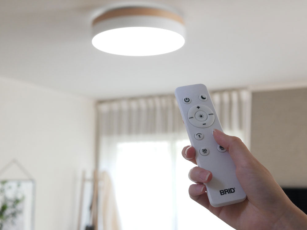 天然木と北欧カラーのBRID Olika LEDシーリングライトがリビングルームの天井に設置されている様子