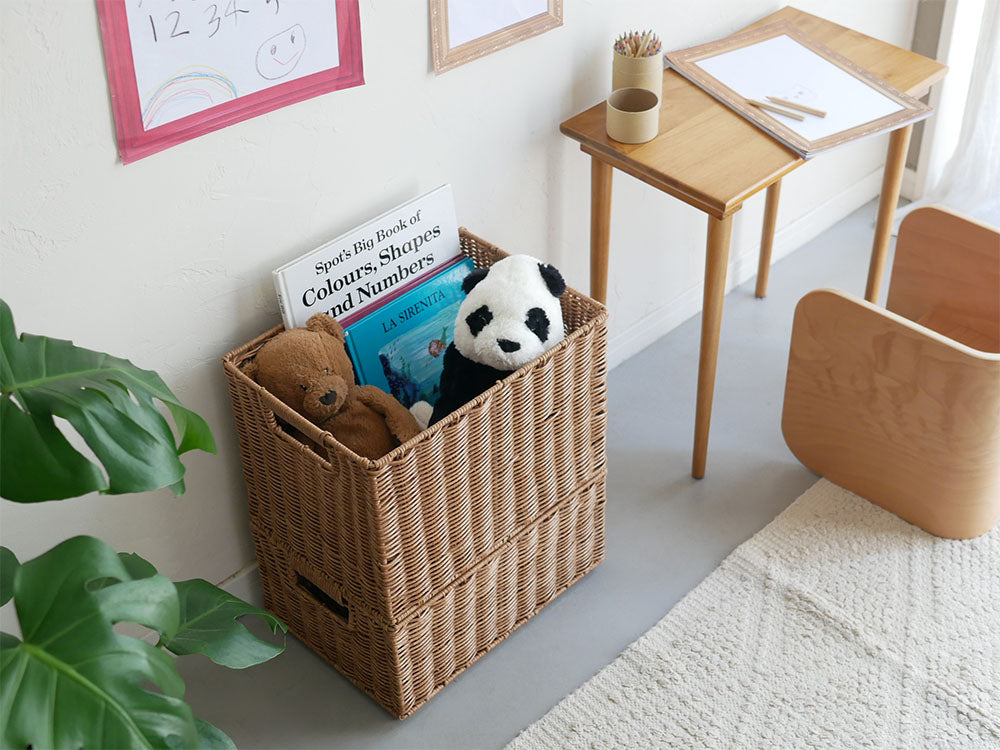 ブラウン色の洗えて隠せるスタッキングバスケットが棚に整然と積み重ねられ、子供用のおもちゃや洗濯物が収納されている様子