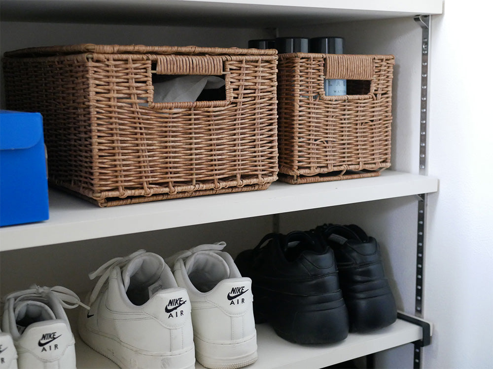 灰色の収納棚に並べられたブラウンの洗えて隠せるスタッキングバスケットとシューオーガナイザー