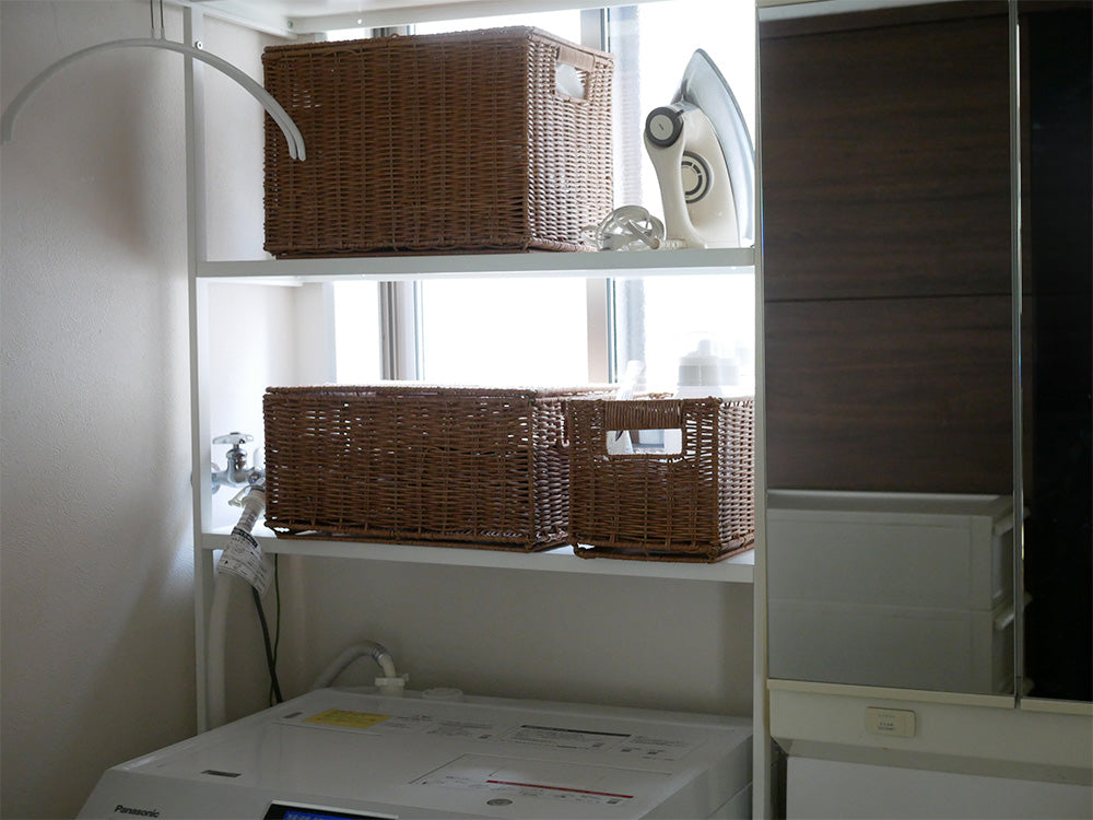 ブラウンの洗えて隠せるスタッキングバスケットが棚に整然と配置されたインテリア