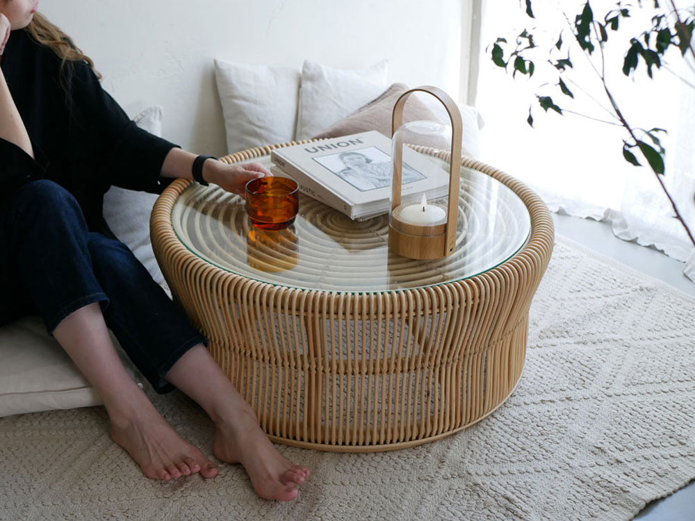 リビングルームに配置されたラタンとガラス製のサンフラワーラタンローテーブル