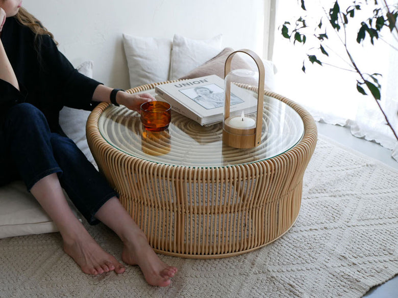 リビングルームに配置されたラタンとガラス製のサンフラワーラタンローテーブル