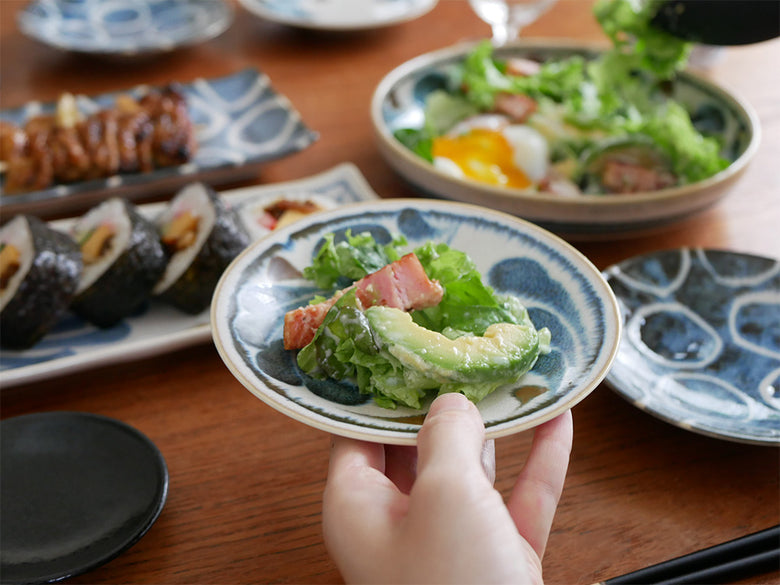 和モダンなアワサカ製ブルー陶器のボウルとプレートが食卓に美しくセッティングされた様子