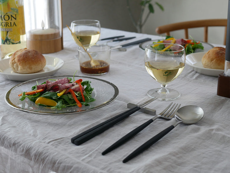 Cutipol（クチポール）のKUBEブラックシルバーお箸セット。天然樹脂と18-10ステンレス製の箸とステンレス製箸置きが並んでいるテーブルウェアの写真