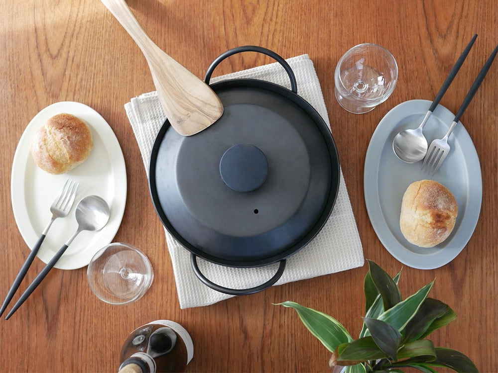 SAKUZAN（サクザン）Sara オーバルプレートの磁器製プレートがテーブルにセットされている写真。サイズL（297×222×22mm）とM（240×165×15mm）が見えます。日本製。