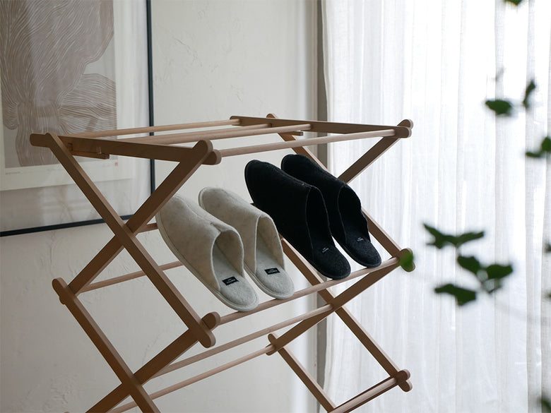 自然素材を使用したクローゼット内に、衣類ハンガー、衣類ホース、バッグ、ロープ、シェルビング、靴オーガナイザーなどの洗濯用品が整然と配置されている様子