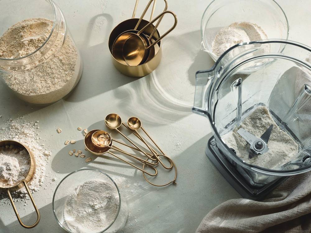 Vitamixのミキサー本体とウェットコンテナ、ドライコンテナ、エアーディスクコンテナが並んだキッチン用品セット