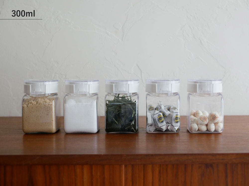 フレッシュロックの食品保存容器とスパイス用メイソンジャーが蓋付きで整然とキッチンに収納されている様子