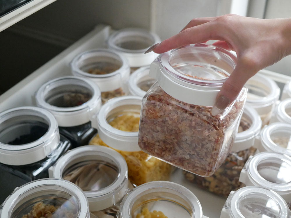 フレッシュロックの透明なマサンジャー型食品保存容器と蓋がキッチンの引き出しに整然と並べられている様子