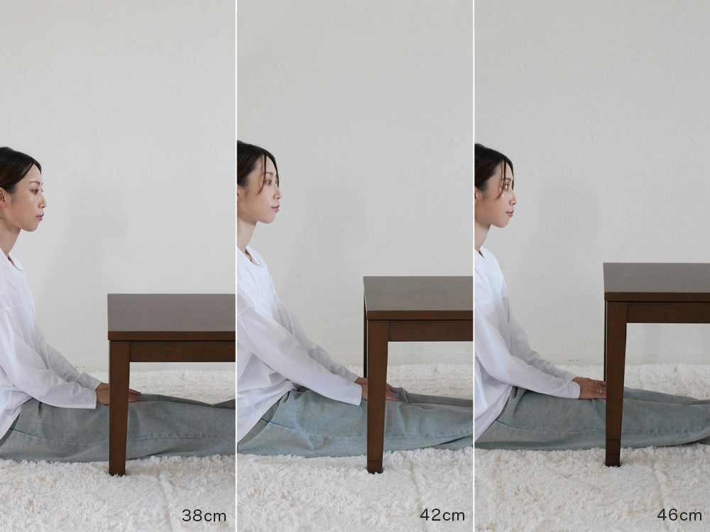 高さ調節可能な1年中使用できるリビングこたつに子供が座り、デスク上のディスプレイデバイスを操作している様子