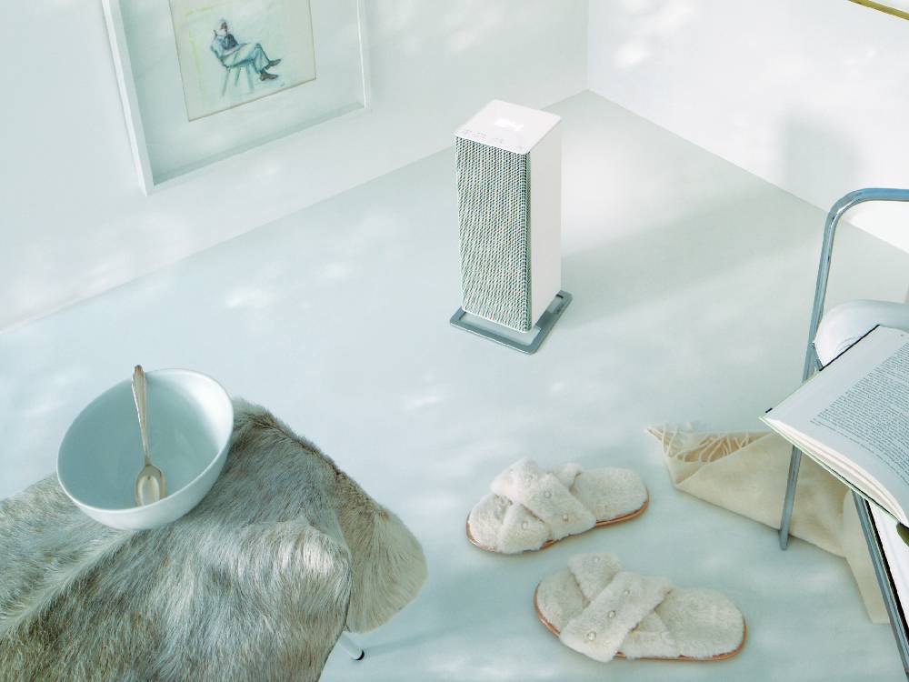 スタドラフォームAnna BIGファンヒーターが銀色の台座の上に置かれ、自然素材の花瓶とともに家庭内で使用されている様子