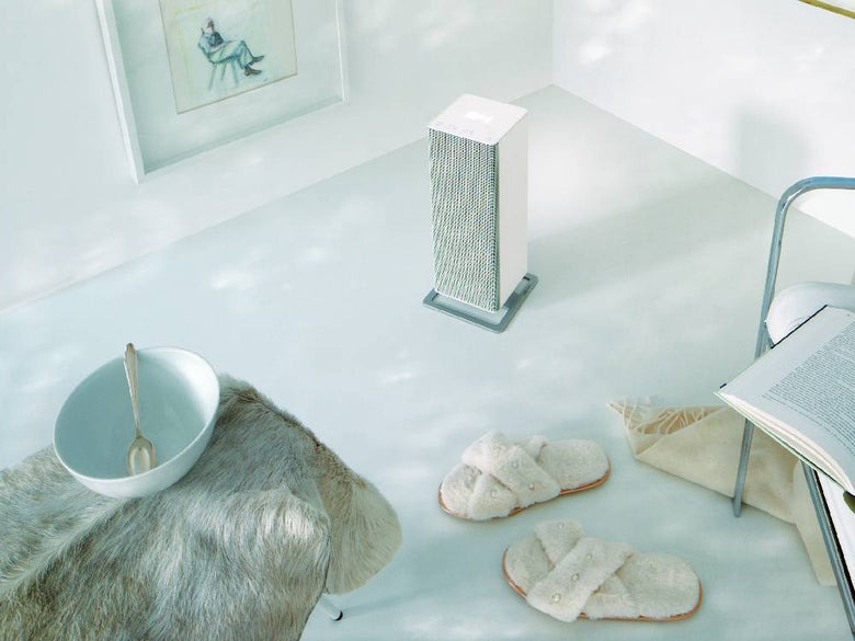 スタドラフォームAnna BIGファンヒーターが銀色の台座の上に置かれ、自然素材の花瓶とともに家庭内で使用されている様子