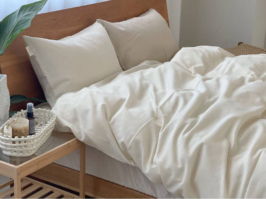 オーガニックコットンのココマニ布団カバーとクッションが整えられたシングルベッドの快適な寝室