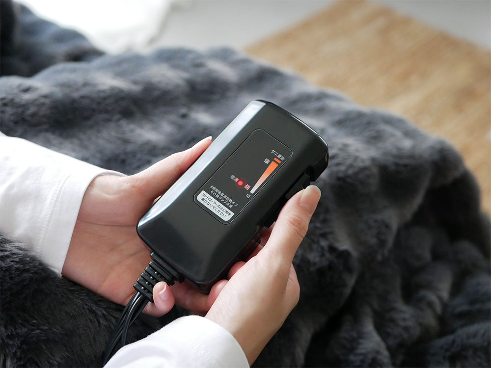 QUADSクワッズ「toron」掛敷両用電気毛布本体とABS製コントローラー、電源アダプターおよび電線が並べられている様子