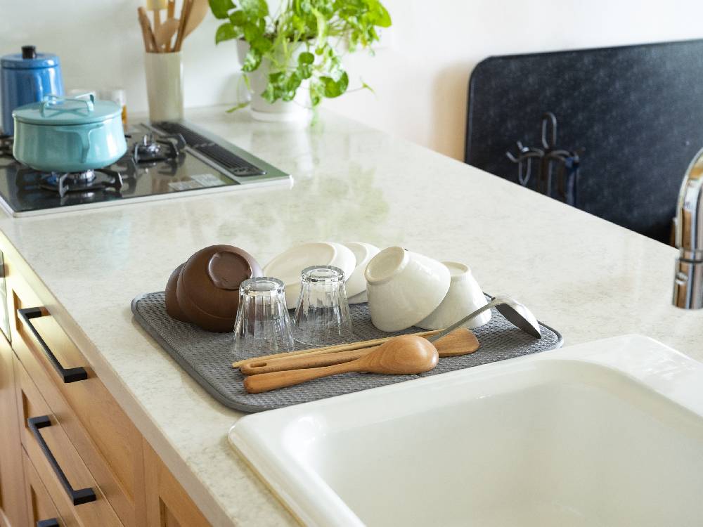 bws SELECTIONのすっきり暮らす水切りマットがキッチンのカウンターに置かれ、シンクや調理器具と共に使用されている様子