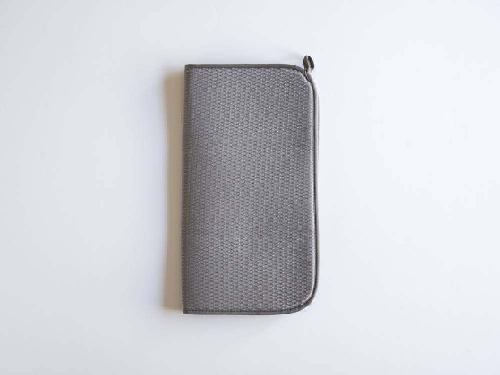 シルバーのレザー製バッグと財布、コインパース、携帯電話ケース、オフィス用品がメッシュやプラスチック素材で整理され、ファスナーで閉じられている様子