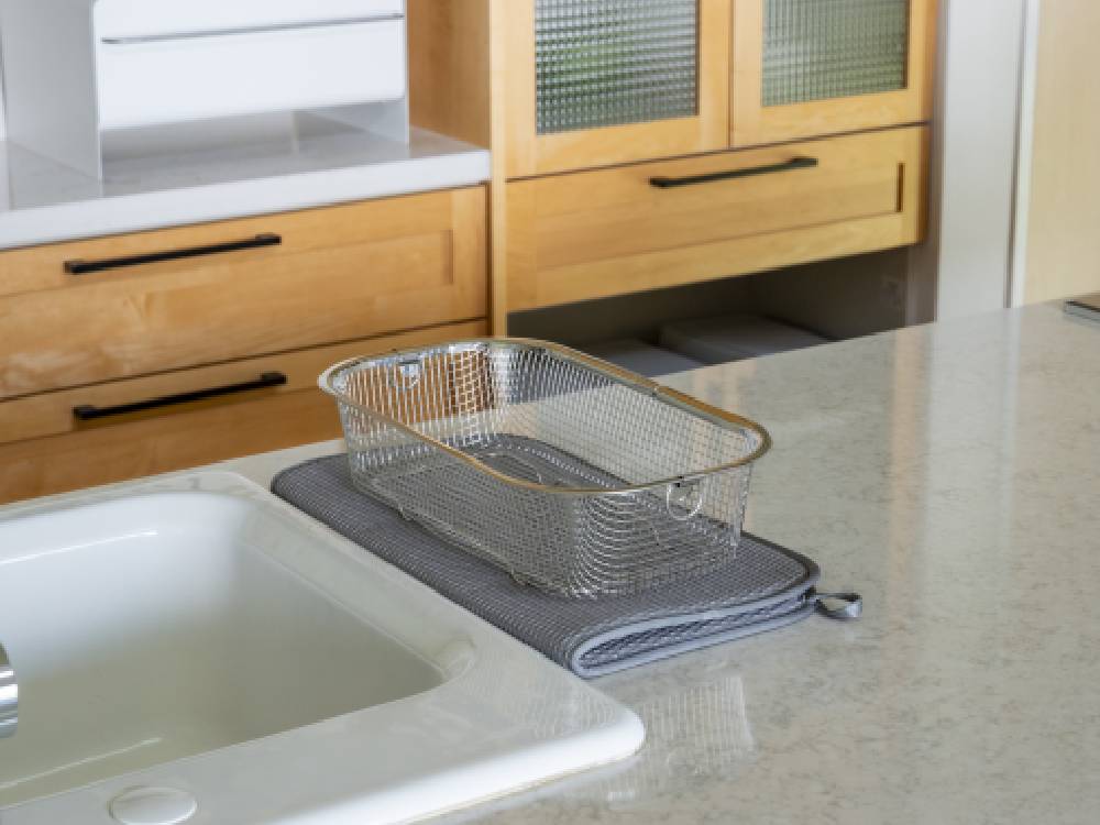 キッチンカウンタートップに置かれた「bws SELECTION」すっきり暮らす水切りマットとシンク、家具が配置されたキッチンの様子