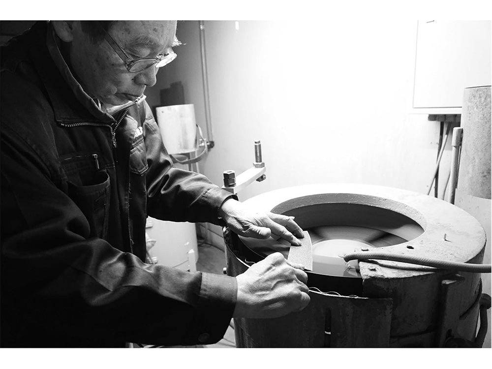 職人の手で協和工業のストーンバリア包丁をシャープナーで研いでいる様子