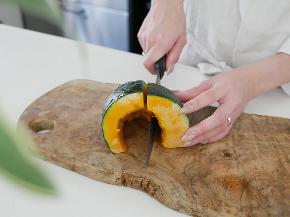 協和工業のストーンバリア包丁ライトタイプとスーパーストーンバリアシャープナーが、果物や野菜と共にカッティングボード上に並べられたキッチン用品の写真