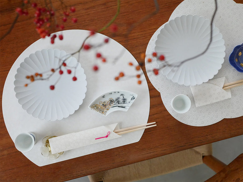 ピンクを基調とした和風テーブルセッティング。美濃和紙のお膳敷紙とお箸包みが並べられている