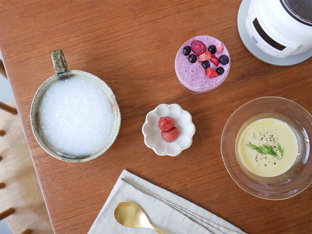 ヒーター機能付きブレンダー「おうちシェフ」とボウル、調理器具、食材が並んだキッチン用品の写真