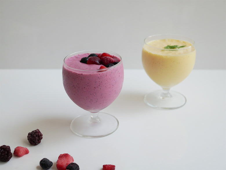 ヒーター機能付きシロカおうちシェフブレンダーと、ベリーやフルーツを使用したスムージーがテーブルウェアと共に並べられている様子