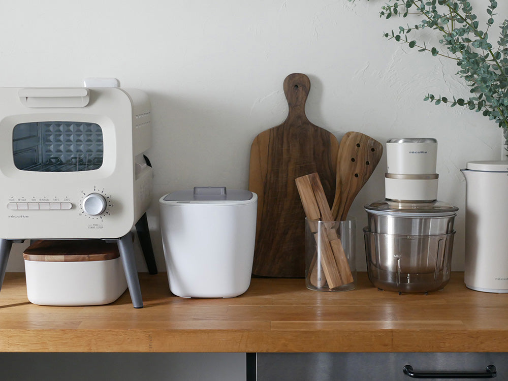 キッチンに置かれたビタントニオの発酵メーカー VFM-10-W本体と付属の容器、スプーンが写っている画像