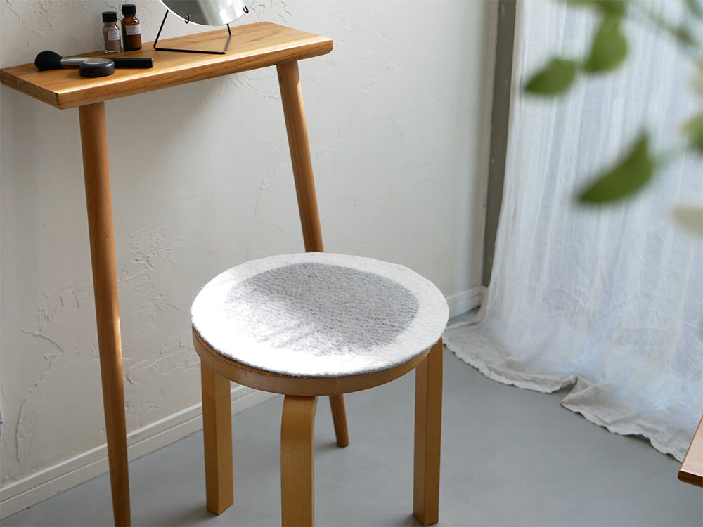 ハードウッドと合板で作られたエンドテーブルの上に、ニュージーランド産ウール100％のウールフェルトチェアシートが置かれている様子
