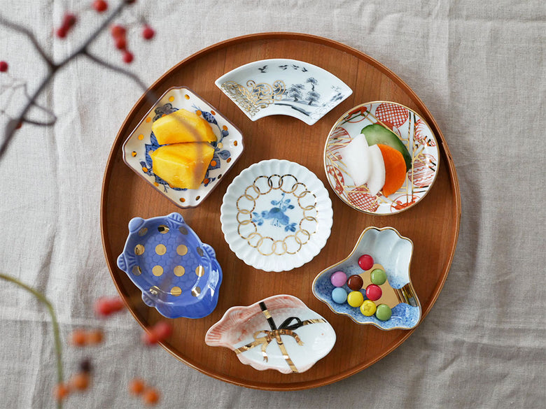 アマブロのMAMEシリーズから、吹墨富士形や吉祥魚形など多様なデザインの磁器皿が並ぶ食器セット