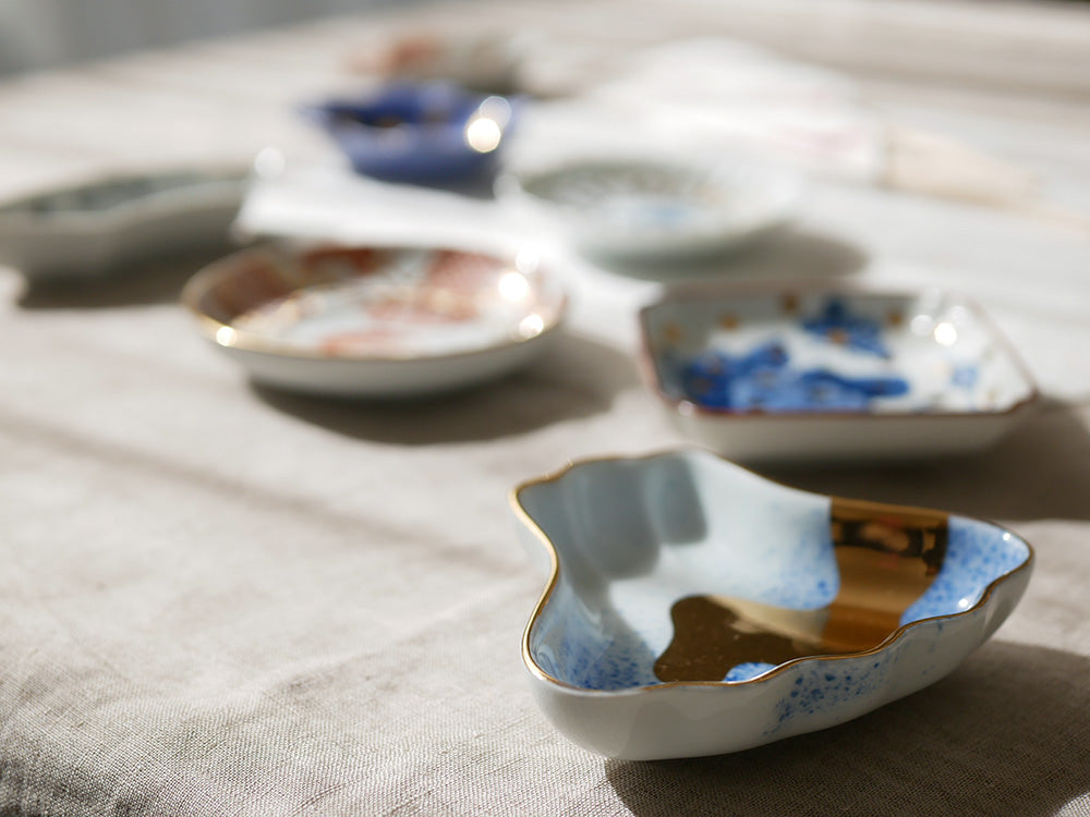アマブロ MAMEシリーズの磁器食器セット。吹墨富士形皿や丸散赤丸など、多彩なデザインのプレートが並んでいます。