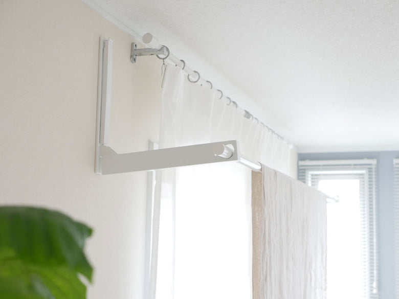 室内に設置されたウォール折り畳み物干し竿ホルダー