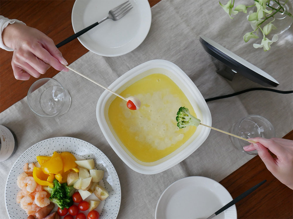 レコルト ポットデュオキャレ卓上電気小鍋と盛り付けられた食器や野菜が並ぶキッチン調理シーン