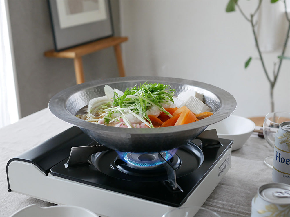 アーネストのとにかく洗いやすいステンレス卓上鍋26cmと21cm、およびのせるだけ簡単蒸し器がキッチンカウンターに並べられている